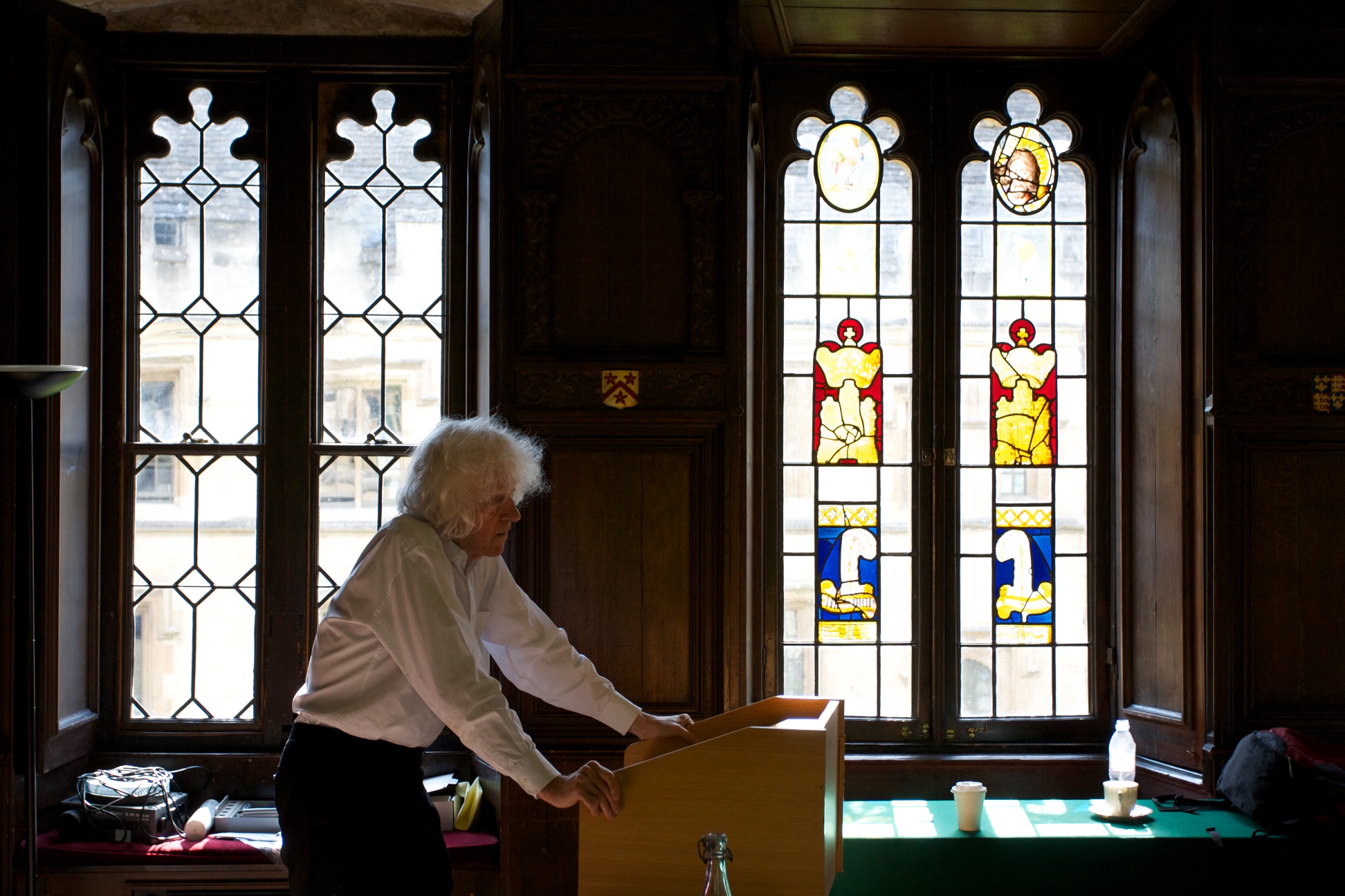 Derek Parfit preparing his presentation beside stained glass windows at All Souls College